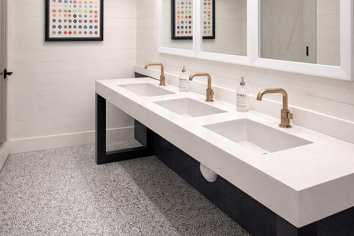 High-traffic airport restroom with commercial touchless sensor faucets designed for reliability and easy maintenance